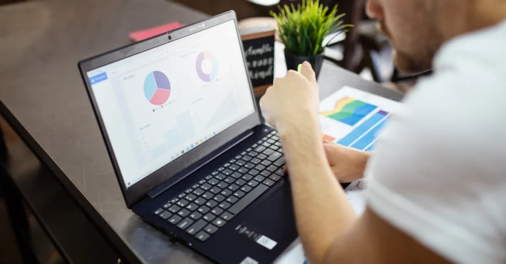 Person analyzing colorful charts and graphs on laptop while reviewing platforms performance data.