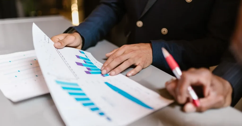 Business professional analyzing blue bar charts with intelligent search technology performance metrics on paper.