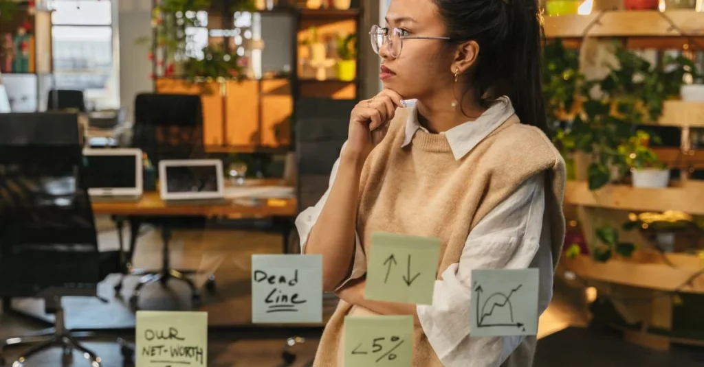 Woman analyzing sticky notes with ecommerce search engine strategy in modern office workspace.