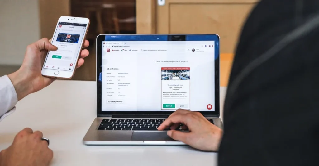 Person comparing ecommerce search functionality on laptop and mobile phone displaying product listings.