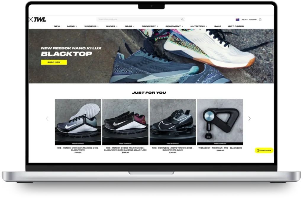 Laptop displaying an online store, featuring Reebok Nano X1 Lux shoes on top.