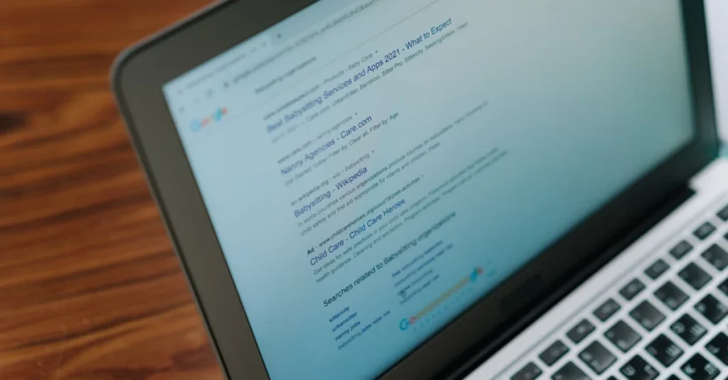 Laptop displaying semantic search results and query interpretation on screen with wooden desk background.